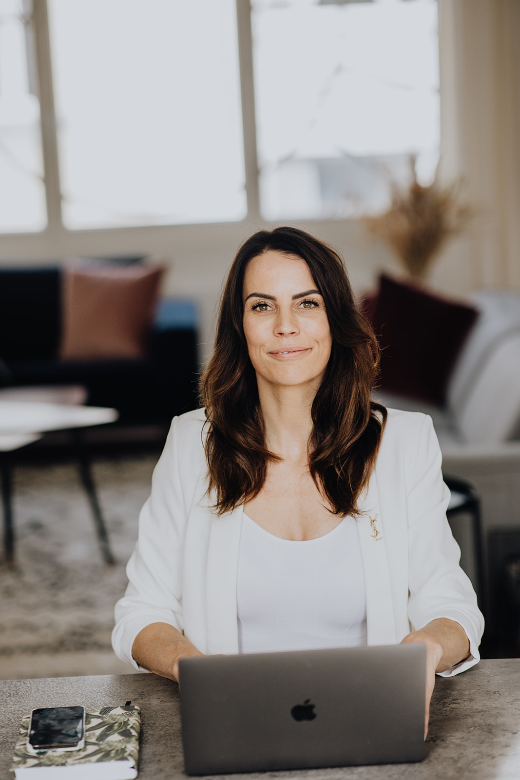 Woman behind apple laptop